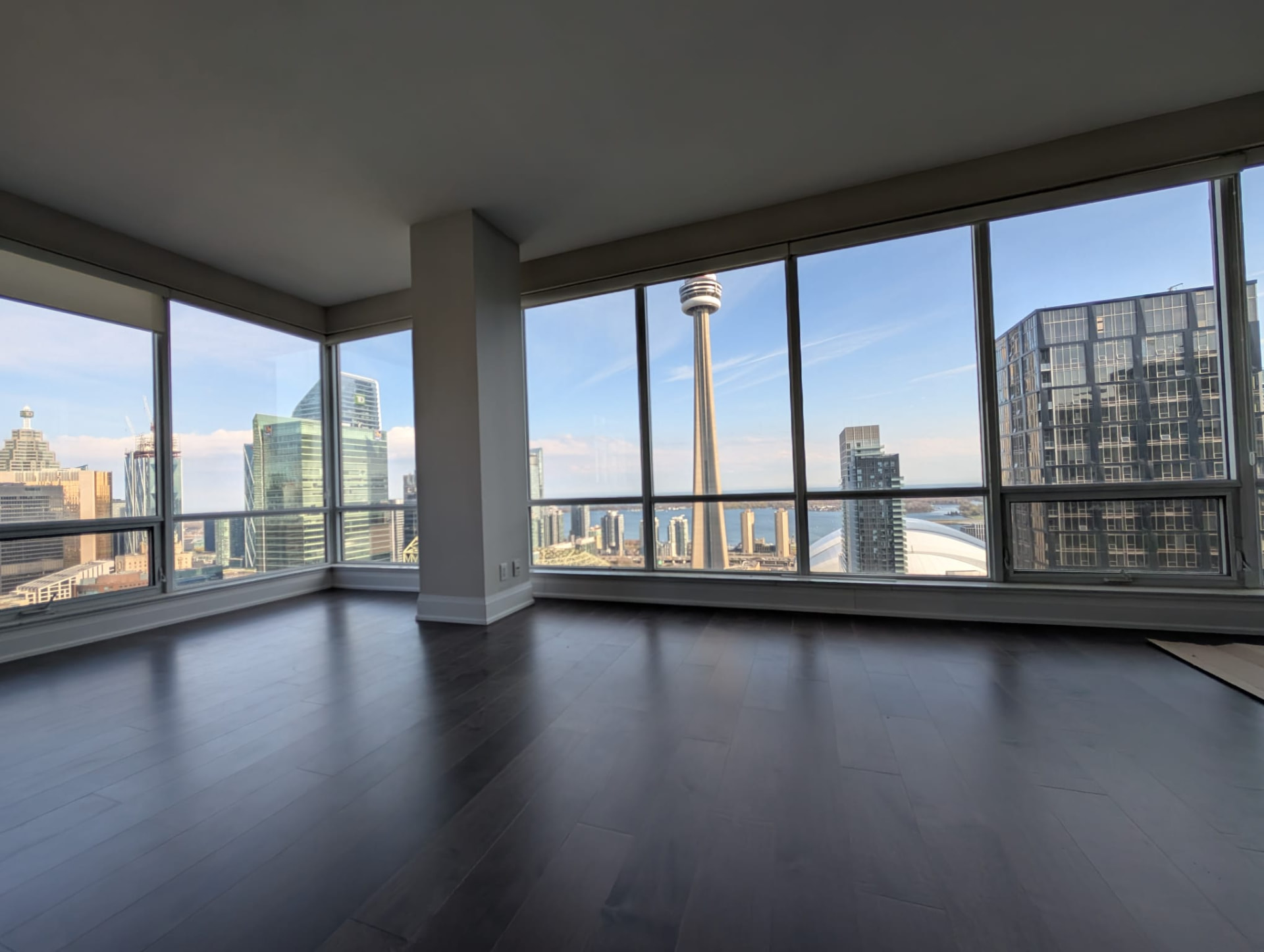 Completed dark hardwood flooring in a downtown Toronto condominium with CN Tower views